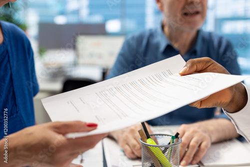 Financial planner giving the pension option contract to senior clients, providing a document with life insurance policy. Banker counseling people to choose a suitable retirement plan.