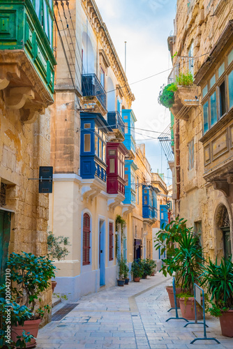 Cozy street and traditional colorful wooden balconies in Birgu, Malta