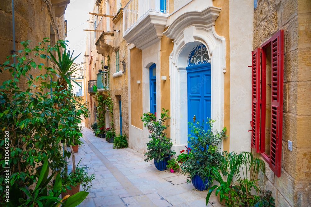 Cozy street and traditional colorful wooden balconies in Birgu, Malta
