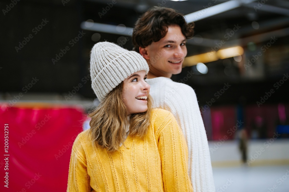 Young couple enjoys ice skating while wearing cozy winter outfits Young couple enjoys ice skating while wearing cozy winter outfits