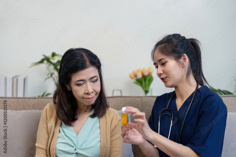 Caregiver explaining medication to elderly patient in a home environment Caregiver explaining medication to elderly patient in a home environment