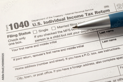 Close-up view of a 1040 U.S. Individual Income Tax Return form with a pen placed on it, highlighting filing status and personal information sections