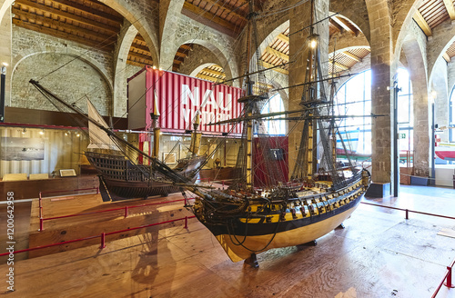 Barcelona, Catalonia, Spain - March 16, 2024: Indoors of two model sailboats on wood floor in exhibition hall of Museu Mar?tim de Barcelona photo