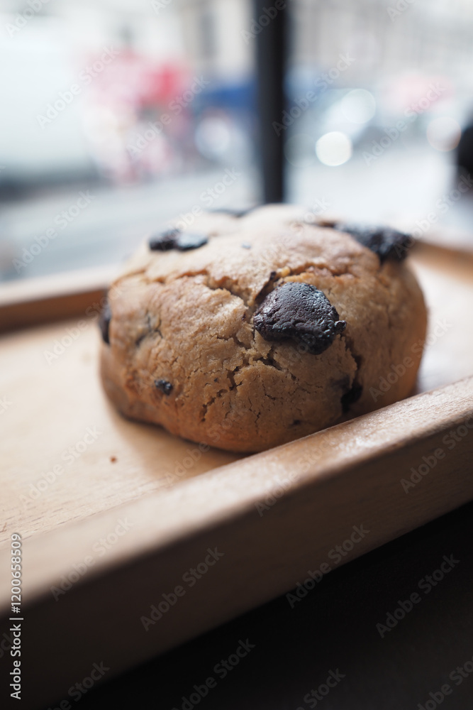 A Freshly Baked Chocolate Chip Cookie Sitting on a Wooden Tray A Freshly Baked Chocolate Chip Cookie Sitting on a Wooden Tray
