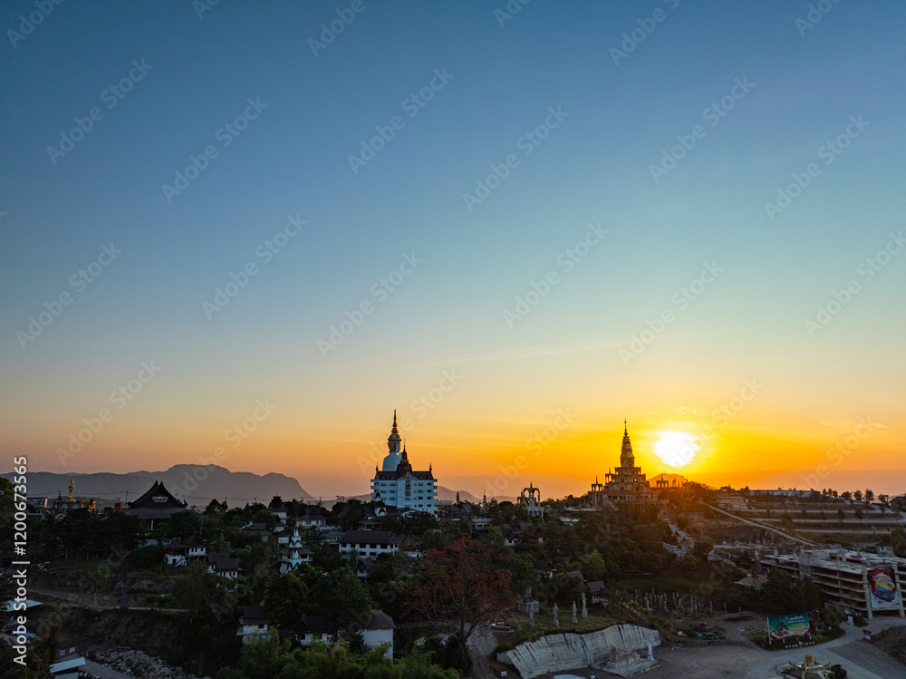 Fototapeta premium Aerial view beautiful golden pavilion at Wat Phachonkeaw at sunrise..5 sitting buddha statues of Phachonkeaw on Khao Kho hill the beautiful landmark .and famous in Phetchabun Thailand.