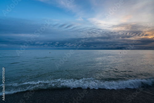 An incoming wave on the Black Sea coast against the sunset sky, Sochi, Krasnodar Territory, Russia photo