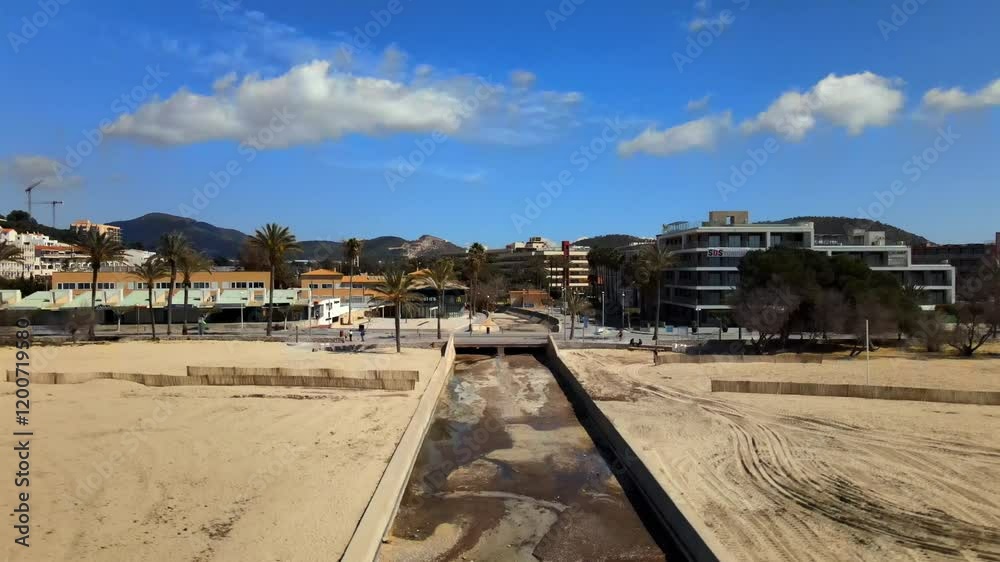 Enjoy a tranquil vista of Santa Ponsa beach in Mallorca, featuring golden sand, a gentle stream, and swaying palm trees under a bright blue sky. Perfect for relaxation and nature lovers. Enjoy a tranquil vista of Santa Ponsa beach in Mallorca, featuring golden sand, a gentle stream, and swaying palm trees under a bright blue sky. Perfect for relaxation and nature lovers.