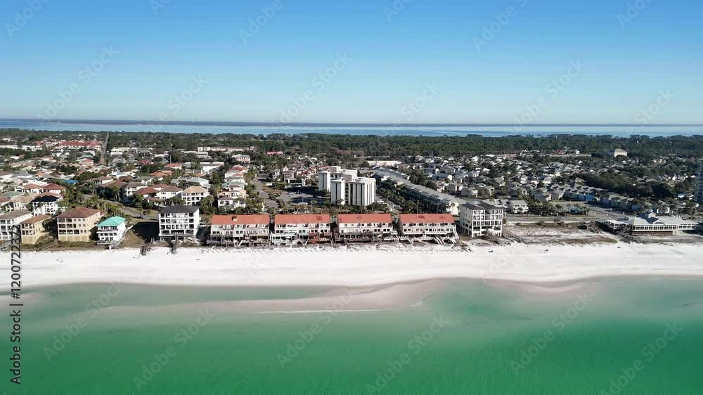An establishing aerial shot showcasing the pristine beaches and beachfront properties of Panama City Beach, Florida, highlighting the coastal beauty and upscale real estate along the Gulf Coast An establishing aerial shot showcasing the pristine beaches and beachfront properties of Panama City Beach, Florida, highlighting the coastal beauty and upscale real estate along the Gulf Coast
