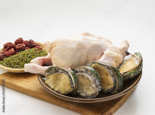 Close up of ingredients for Chicken porridge like raw chicken, abalone, Nogdu(Mung bean)s and jujube on dish and wood cutting board, South Korea photo