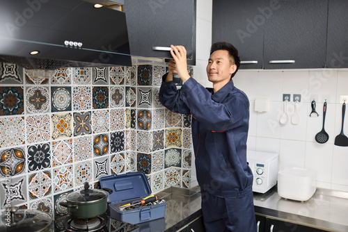 Handyman repairing the kitchen cabinet