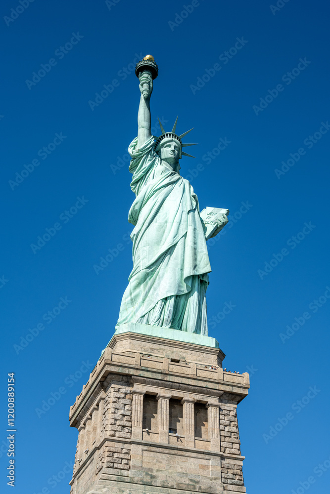 Fototapeta premium The famous Statue of Liberty in New York in front of a blue sky
