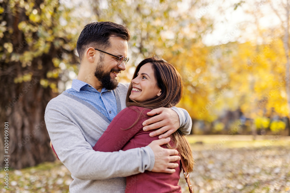 Joyful romantic couple hugging and smiling at each other in city park on valentines. Joyful romantic couple hugging and smiling at each other in city park on valentines.