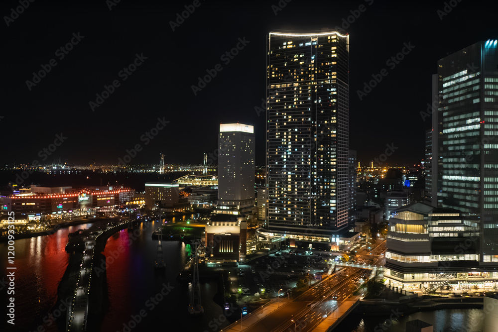 日本の横浜。高層ビルの明かりが運河に反射する夜景。