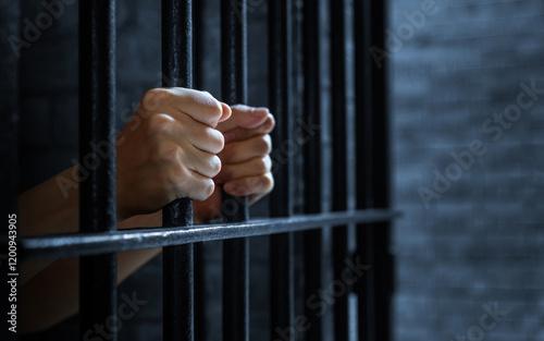 Women's hands holding prison railings
