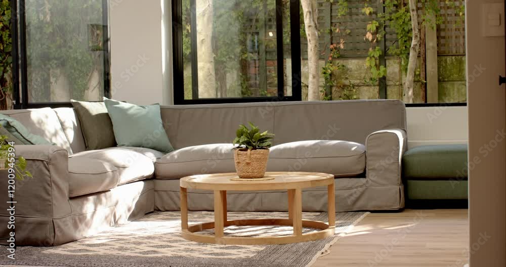 Modern living room with cozy sectional sofa and coffee table, bright natural light, copy space