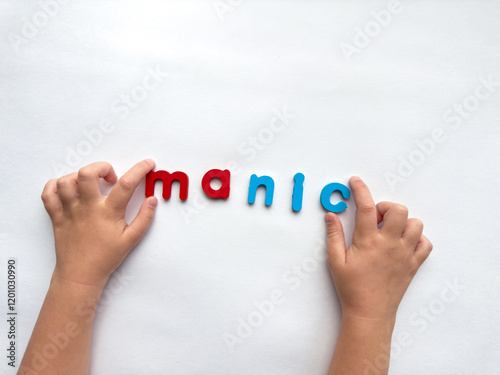 Child spelling with colorful letters manic on white background