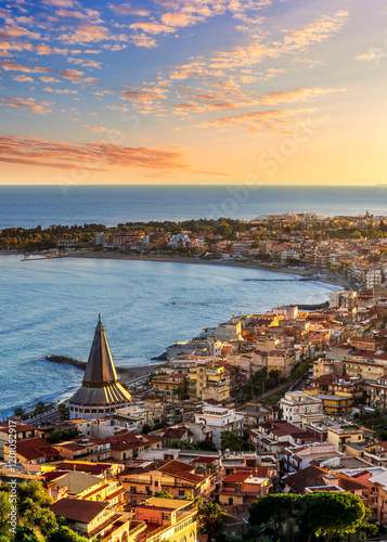 seascape panorama of mediterranean coast landscape with old italian town in golden sunset sun rays and beautiful evening blue sea gulf