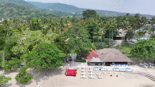 Resort and palm trees, drone reveal sandy beach of Senggigi, famous recreation spot in Lombok. photo