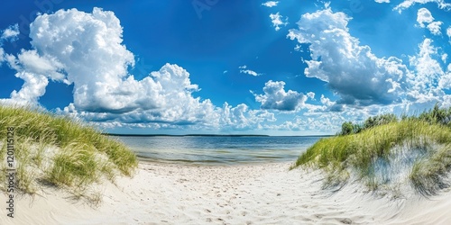 Fototapeta Naklejka Na Ścianę i Meble -  Panoramic view of the Baltic Sea from a sandy beach with vibrantly colored clouds and green grass under bright blue skies on a sunny summer day