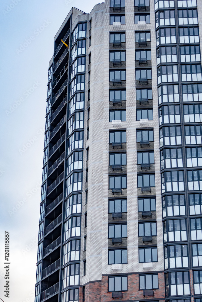 A tall building with many windows and a yellow sign on the roof A tall building with many windows and a yellow sign on the roof