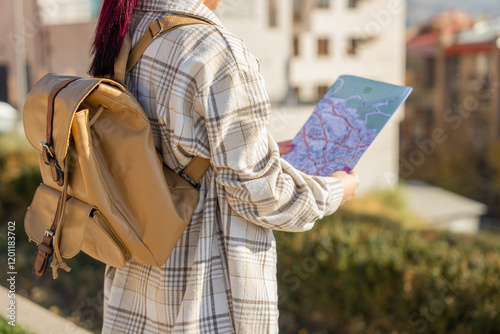 Tourist with map in hand orienting himself in the city photo