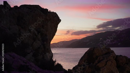 A breathtaking sunset in Spain with rugged cliffs, vibrant skies, and calm Mediterranean waters, capturing the beauty and tranquility of the coast. photo