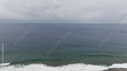 Droen flyby shot over empty South Pacific Ocean under heavy dense clouds in Cook Islands.