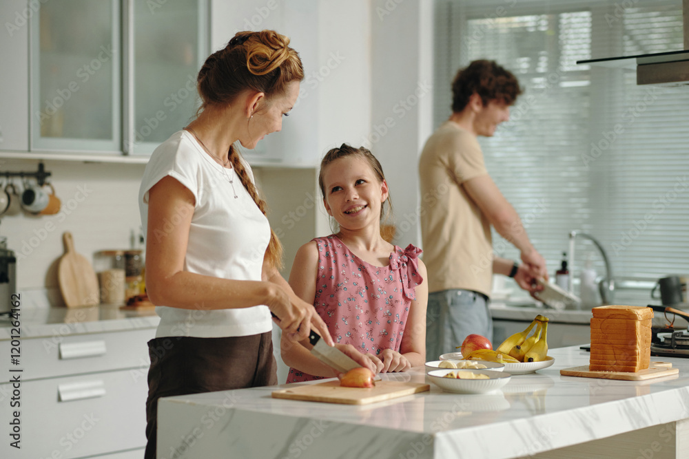 Happy family of three cooking together in the kitchen Happy family of three cooking together in the kitchen