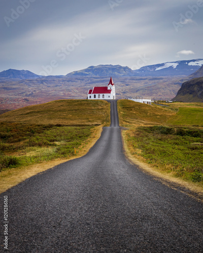 Ingjaldsholskirkja church at the top of the hill with thw road leading to it, Ingjaldsholl, Snaefellsnes peninsula, Iceland. photo