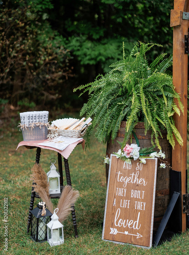 Wedding decorations for an outdoor wedding ceremony in the forest close-up. The wishes of the newlyweds, a fan, candles and a fern on a barrel as an element of decor at a wedding ceremony for guests photo