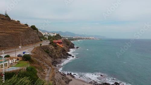 A breathtaking drone view of Spain’s Mediterranean coastline, featuring winding roads, rocky cliffs, and turquoise waters. A perfect scene of natural beauty and coastal charm. photo