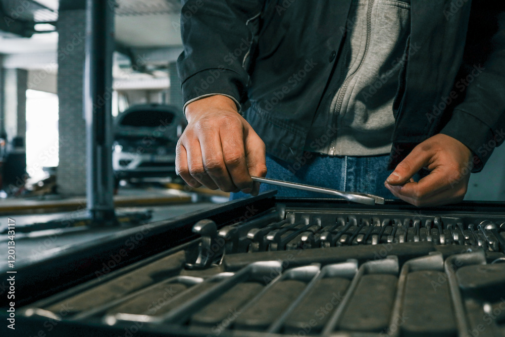 Close-up of a mechanic's hand picking wrenches from a well-organized tool tray in a workshop. Metal wrenches in various sizes, ready for repair tasks Close-up of a mechanic's hand picking wrenches from a well-organized tool tray in a workshop. Metal wrenches in various sizes, ready for repair tasks