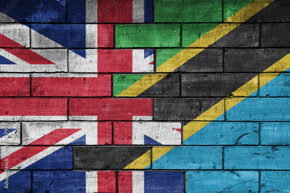 colourful painted big flag of great britain and flag of tanzania on a massive old brick wall background. concept colourful painted big flag of great britain and flag of tanzania on a massive old brick wall background. concept