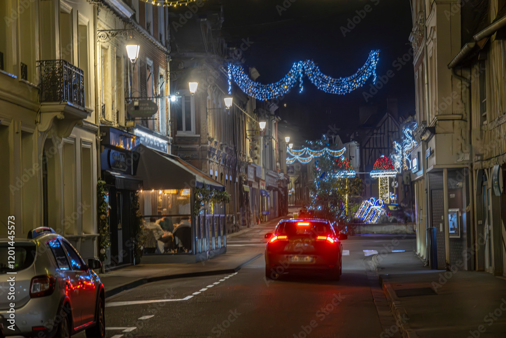 Obraz premium Normandy, France -12- 30- 2024 : Exterior night photo view of christmas light decorations for xmas celebrations decor evening with garlands and tinsel lights,