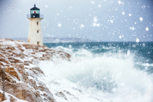 Blizzard envelops Peggy's Cove Lighthouse while waves crash against the shore