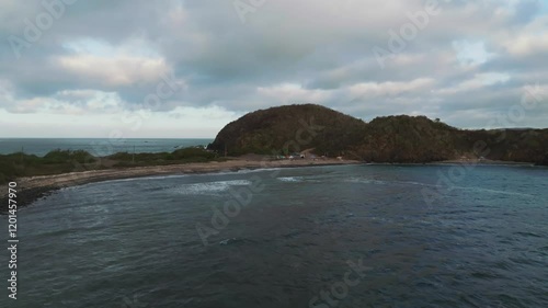 A stunning aerial dolly forward capturing beachgoers camped on the golden sands of Playa La Morita at sunset. Located in Tenacatita, Jalisco, this scene radiates tropical charm and serene beauty photo