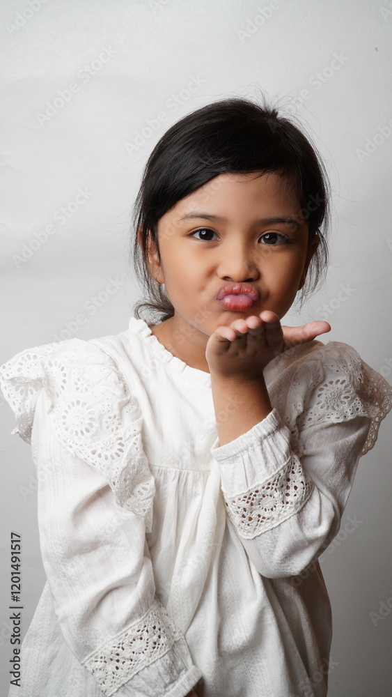 Portrait of an Asian girl wearing a white shirt posing for a kiss bye on a white background.
Portrait of an Asian girl wearing a white shirt posing for a kiss bye on a white background.