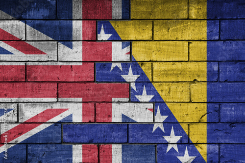 colourful painted big flag of great britain and flag of bosnia and herzegovina on a massive old brick wall background. concept photo