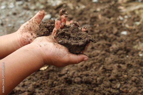 Close up of a little boy's hands playing with dirt or sand. child playing outdoors