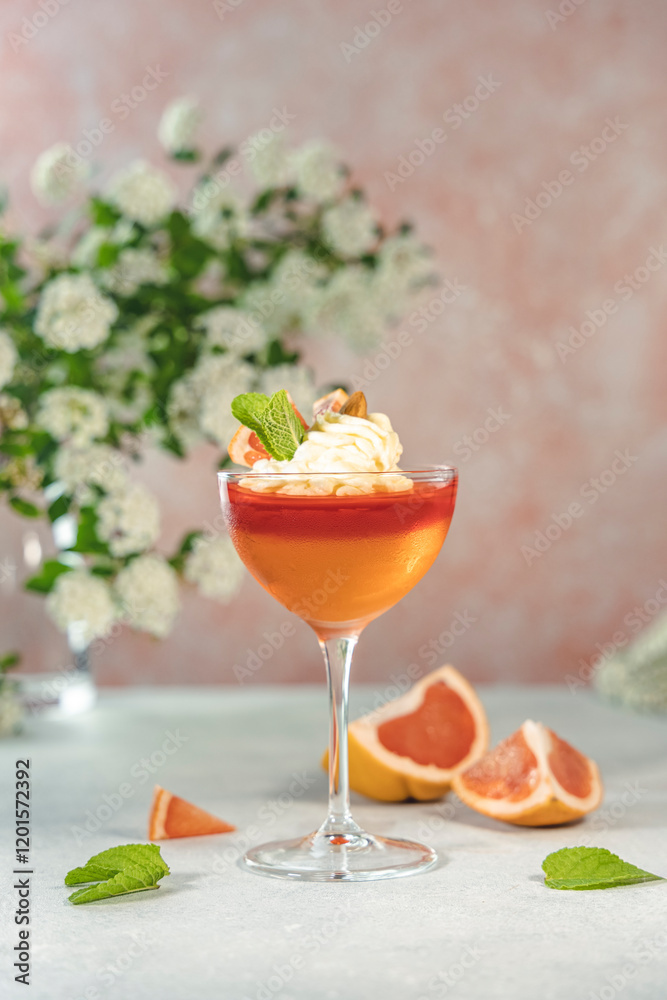 Grapefruit and orange jelly dessert garnished with whipped cream and mint Grapefruit and orange jelly dessert garnished with whipped cream and mint