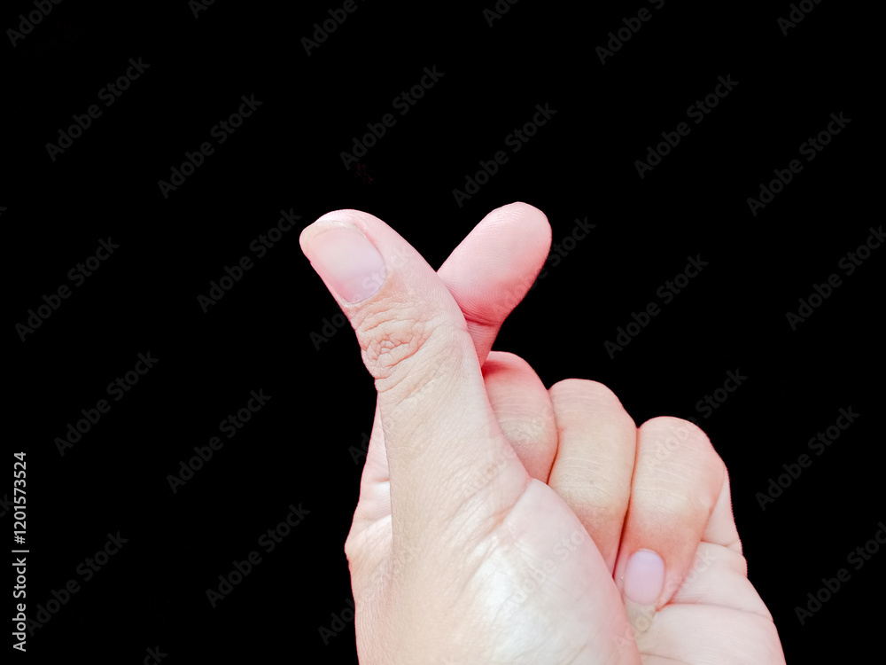 Human hand making a heart-shaped sign with both fingers as a symbol of love, affection, valentine's day, liking and appreciation concept. Isolated on dark background. Human hand making a heart-shaped sign with both fingers as a symbol of love, affection, valentine's day, liking and appreciation concept. Isolated on dark background.
