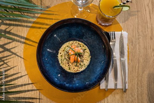 Fototapeta Naklejka Na Ścianę i Meble -  Une soupe aux crevettes dans une assiette posée sur une table dans un restaurant gastronomique