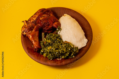 Crisped grilled quarter chicken, accompanied by traditional African food (ugali) and stir-fried kale	