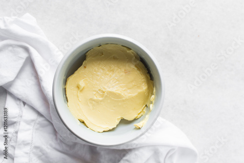 Overhead view of organic butter in a white plate with handle, natural butter from grass fed cows photo