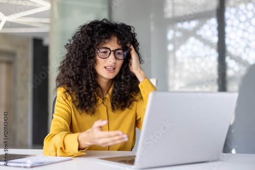 Upset and dissatisfied woman using laptop for video call. Office worker in glasses frustrated communicating with colleagues and partners remotely, online business meeting conference.