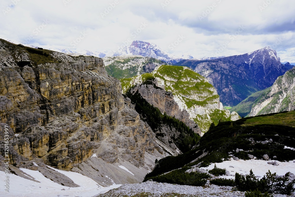Obraz premium Panoramic alpine valley with snow-covered slopes and limestone peaks in the Dolomites, Italy