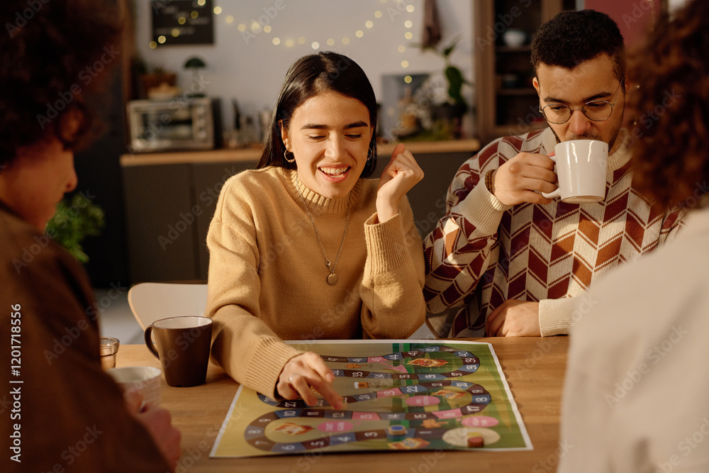 Fototapeta premium Medium close up of brunette woman enjoying her game turn while her boyfriend who sitting near her drinking tea