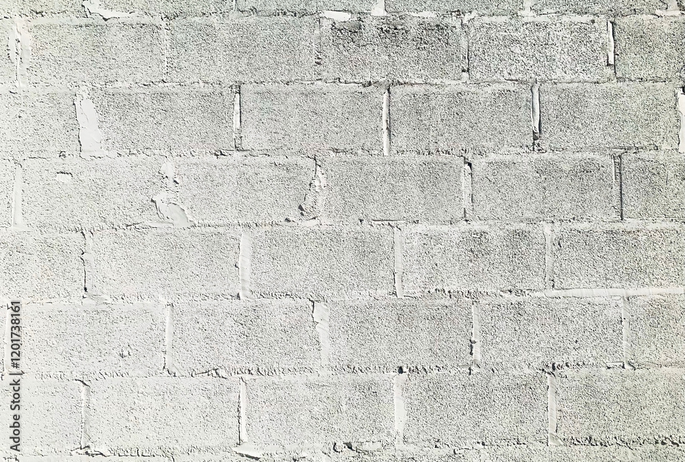 Fototapeta premium A minimalist white concrete wall with rough textures and visible mortar lines, perfect for design backgrounds or industrial aesthetics.