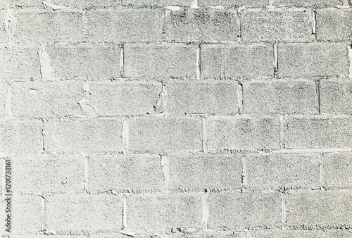 A minimalist white concrete wall with rough textures and visible mortar lines, perfect for design backgrounds or industrial aesthetics.
