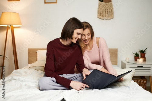 Two stylish young people share joyful moments as they reminisce over memories in a cozy setting.